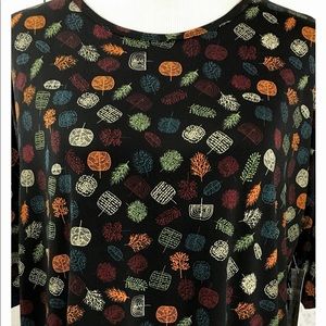 LuLaRoe S Irma Tunic Top, half sleeve, black background with colorful foliage.